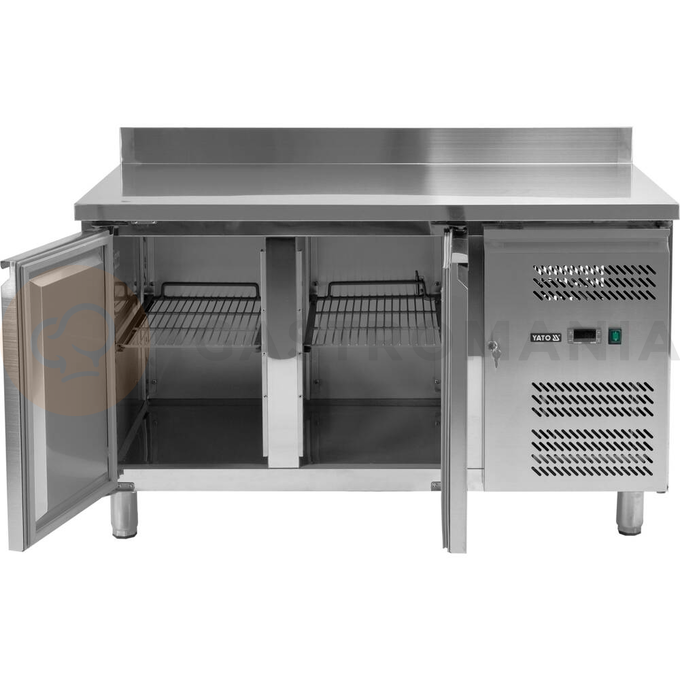 Stół chłodniczy 2-drzwiowy z blatem roboczym z rantem marki YATO YG-05250.
Stół chłodniczy o wymiarach 1360x700x950mm ma pojemność komory 282L. Przeznaczony jest do przechowywania żywności w zakresie temperatur -2~+8°C.
Doskonale nadaje się do wszelkiego typu punków gastronomicznych takich jak restauracje, bary, puby czy pizzerie.
Obudowa zewnętrzna i wewnętrzna wykonana z wysokiej jakości stali nierdzewnej SS201 gwarantuje elegancki wygląd, a jednocześnie jest bardzo łatwa w utrzymaniu w czystości. Blat posiada dodatkowy rant tylny o wysokości 100mm. Stół wyposażony jest w 4 nóżki z regulacją wysokości w zakresie 120~180mm.
Boczny agregat chłodniczy o mocy 215W wykorzystuje czynnik chłodniczy R290 dedykowany do pracy w 4 klasie klimatycznej, przy maksymalnej temperaturze otoczenia 30°C i wilgotności względnej 55%. Zasilany jest prądem o napięciu 220-240V ~50Hz. Elektroniczny sterownik marki Dixell z cyfrowym wyświetlaczem temperatury. Średnie roczne zużycie energii 827 kWh.
Urządzenie posiada chłodzenie wymuszone oraz funkcję automatycznego odszraniania.
Model z dwoma samozamykającymi się drzwiami z wygodnymi uchwytami do otwierania. Na każde drzwi ma w zestawie po 1 półce rusztowej powlekanej PVC o nośności max 40kg - przy równomiernym obciążeniu. Umożliwia przechowywanie pojemników GN 1/1.
 | YG-05250, Stół chłodniczy 2-drzwiowy - linia 700